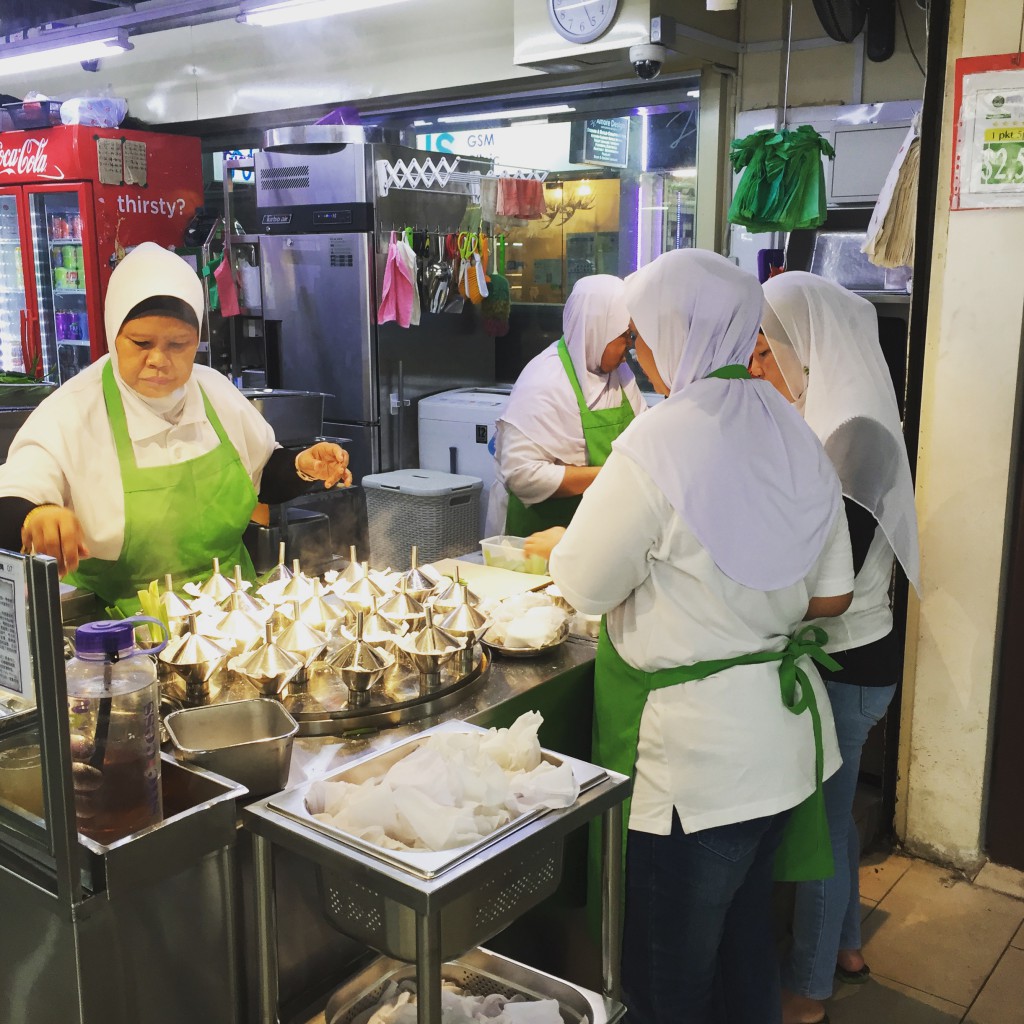 The chefs steaming putu piring at a hawker stall in Singapore.