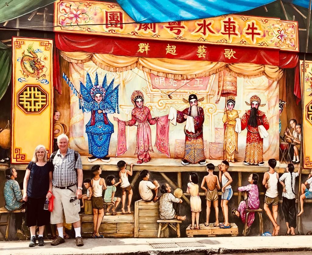 Tourists having a phot next to Yip Yu Chong's street art mural in Chinatown Singapore